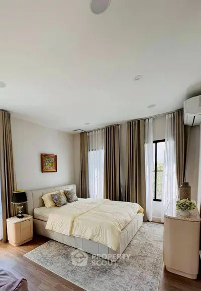 Elegant bedroom with modern decor and large windows for natural light.