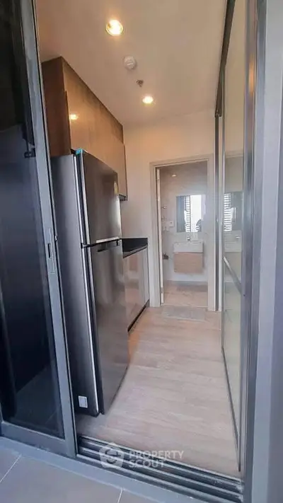 Modern kitchen with sleek design and stainless steel fridge in a contemporary apartment.