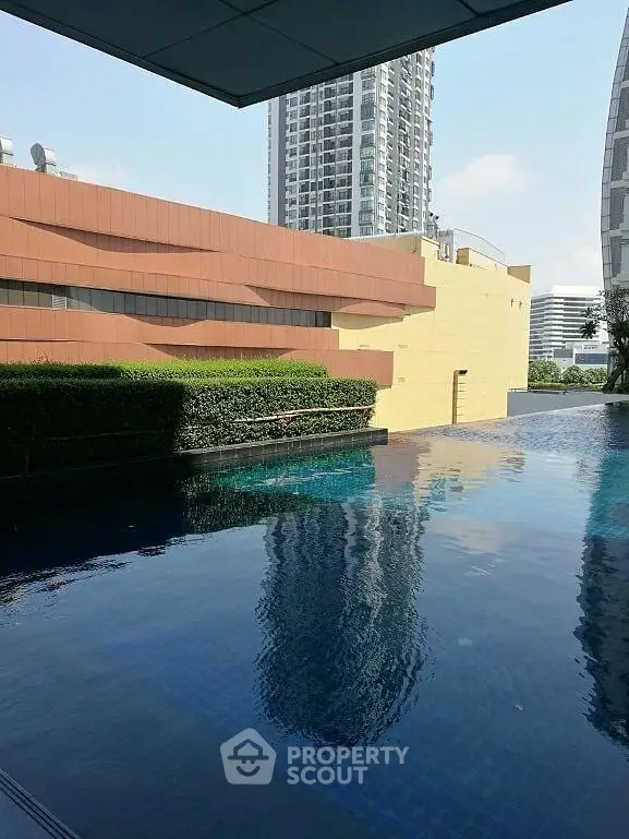 Luxurious high-rise building with serene pool and modern architecture.