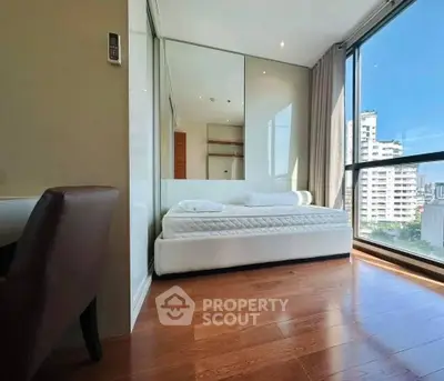 Modern bedroom with large windows and city view, featuring sleek wooden flooring and minimalist design.