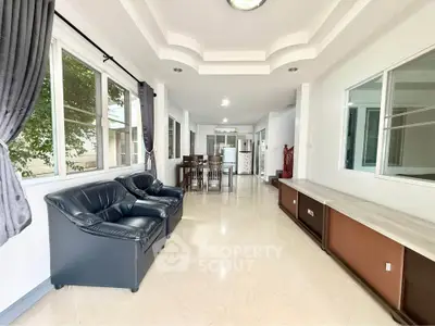 Spacious living room with modern furniture and large windows in a bright, airy home.