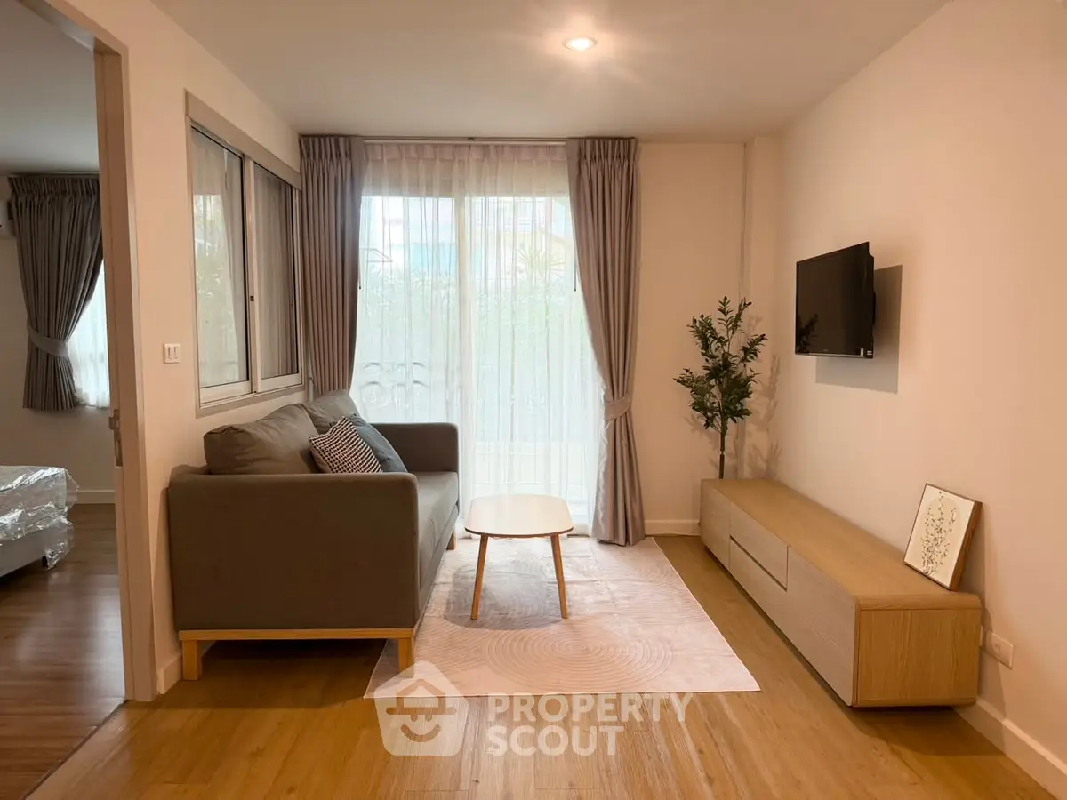 Modern living room with cozy sofa, wall-mounted TV, and elegant decor in a bright apartment.