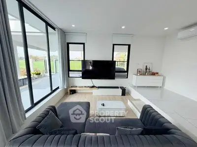 Modern living room with large windows and stylish furniture, offering a bright and spacious atmosphere.