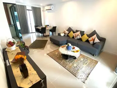 Spacious modern living room with sleek grey sofas, elegant decor, and a seamless transition to the dining area, perfect for entertaining and relaxation.