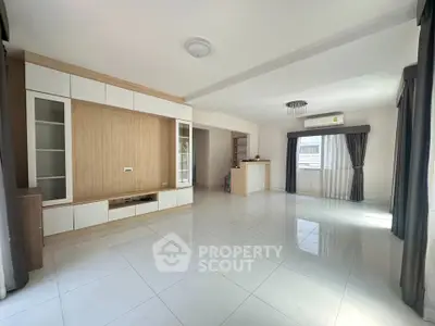 Spacious modern living room with large windows and sleek built-in storage