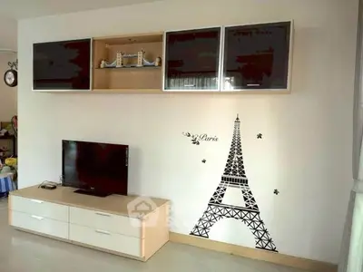Modern living room with Eiffel Tower wall decal and sleek TV unit.