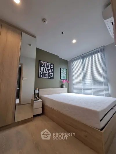 Modern bedroom with stylish decor and natural light, featuring a comfortable bed and sleek wooden furniture.