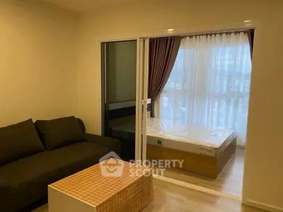 Cozy studio apartment with sliding glass partition and modern furnishings.