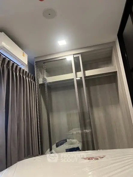 Modern bedroom with built-in wardrobe and air conditioning unit