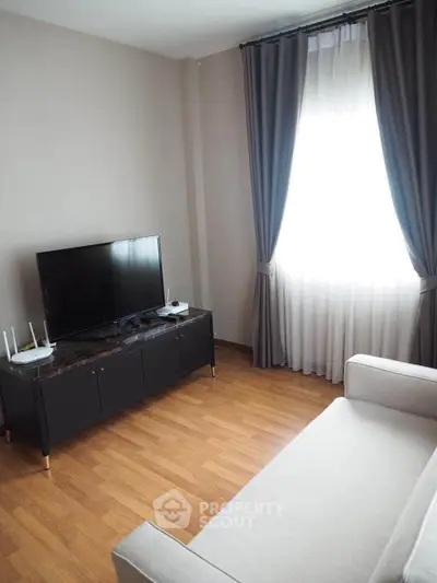 Modern living room with sleek TV stand, elegant curtains, and cozy sofa, perfect for relaxation.