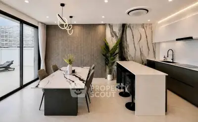Luxurious modern kitchen with marble countertops and open layout, featuring elegant dining area and stylish lighting.