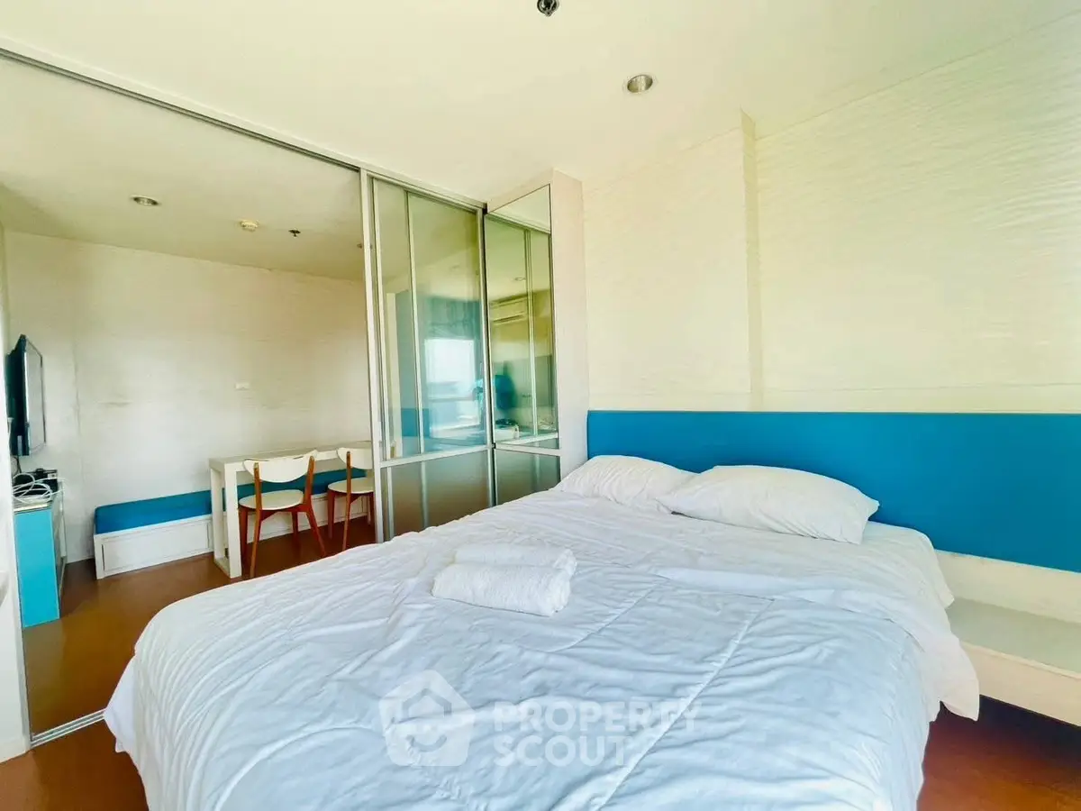 Bright modern bedroom with blue accents and sliding glass doors