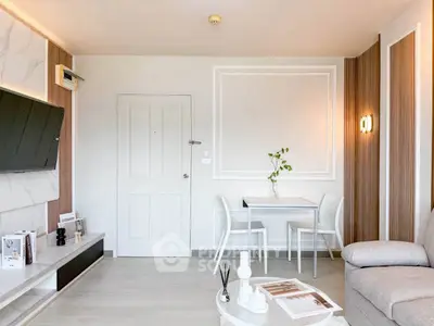 Modern living room with elegant decor and stylish furniture, featuring a wall-mounted TV and a cozy seating area.