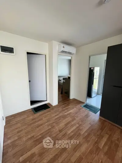 Modern interior room with wooden flooring and air conditioning, showcasing sleek design and ample natural light.