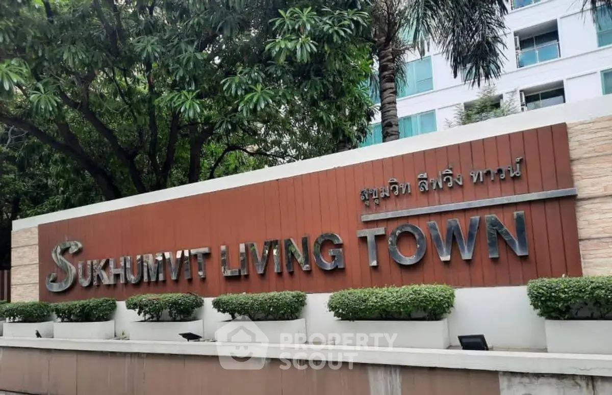 Sukhumvit Living Town entrance sign with lush greenery and modern building backdrop.