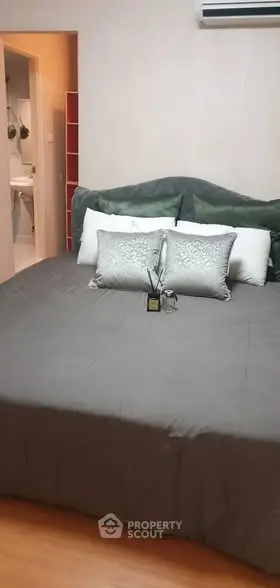 Cozy bedroom with elegant bedding and air conditioning, perfect for relaxation.