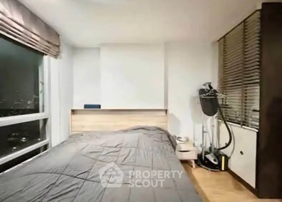 Modern bedroom with city view, featuring sleek design and ample natural light.