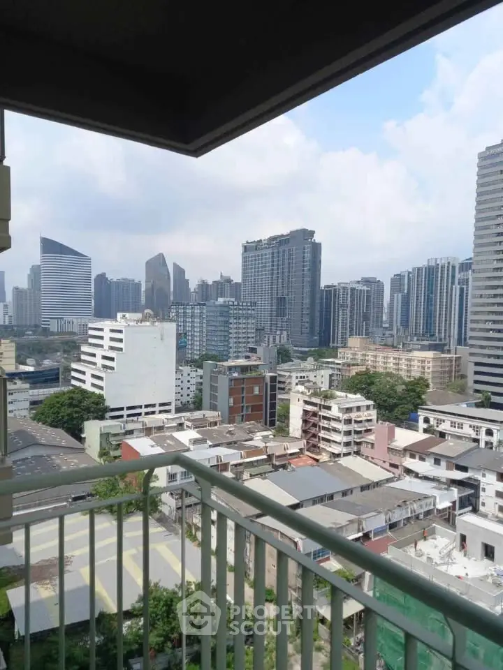 Stunning cityscape view from a high-rise balcony overlooking modern skyscrapers and urban landscape.
