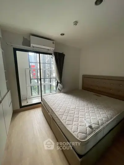 Cozy bedroom with balcony access in modern apartment, featuring natural light and sleek design.