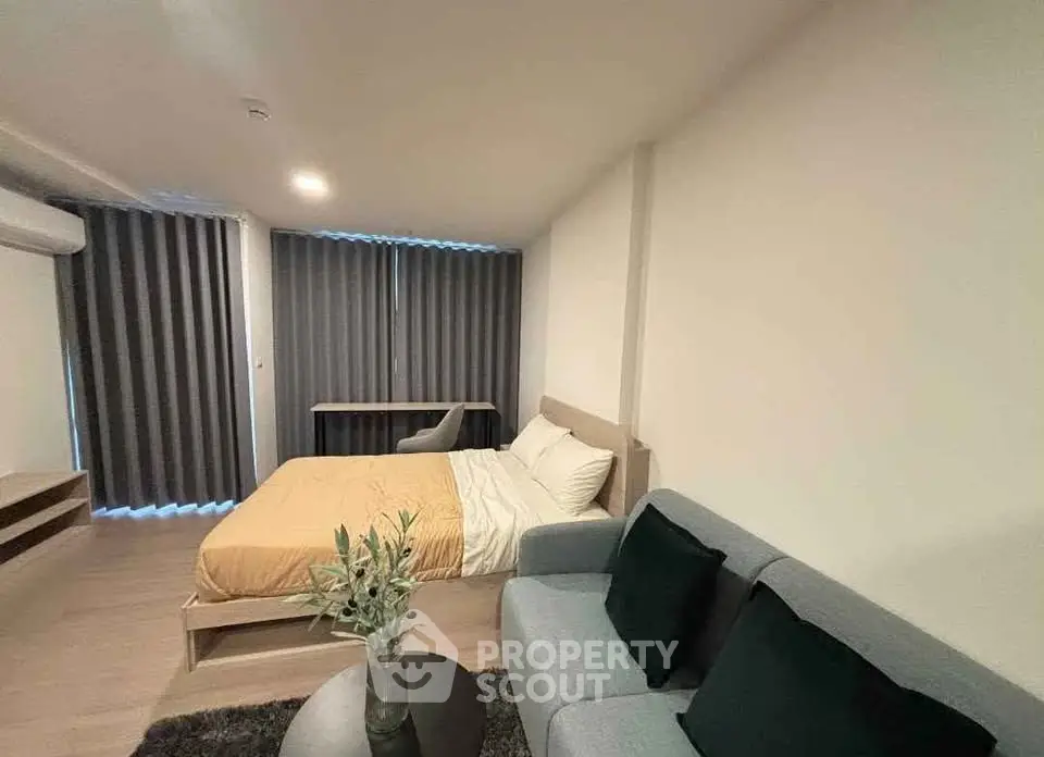 Modern bedroom with cozy bed, stylish sofa, and elegant decor in a contemporary apartment.