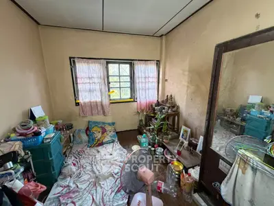 Cozy bedroom with natural light and personal touches, ideal for creative living.