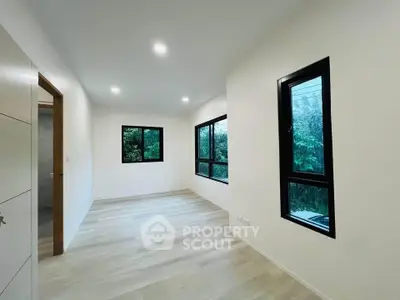 Spacious modern bedroom with large windows and natural light