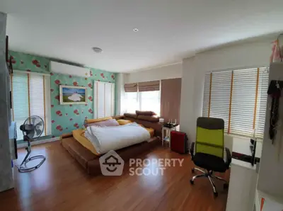 Spacious bedroom with modern decor and natural light, featuring a cozy bed and stylish furnishings.