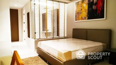 Elegantly designed bedroom with modern furnishings, plush bedding, and vibrant artwork creating a welcoming ambiance.