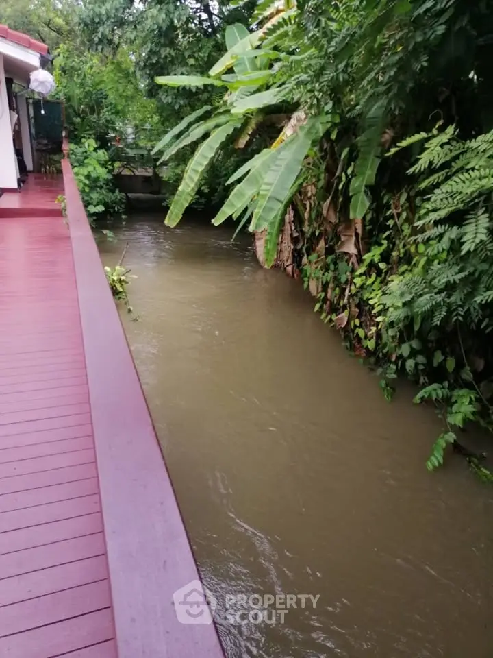 Charming riverside property with lush greenery and serene waterway view.