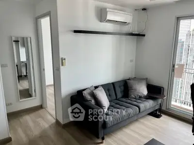 Modern living room with sleek sofa and air conditioning, featuring a balcony view.