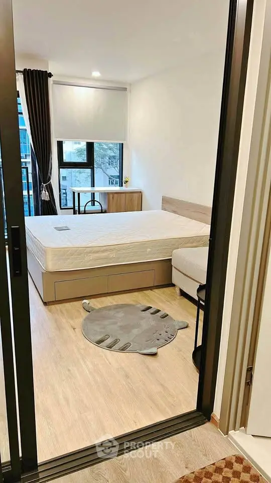 Modern bedroom with large window and minimalist decor in urban apartment