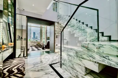 Luxurious marble staircase leading to a modern living room with city view.