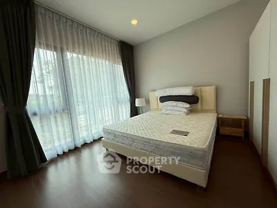 Spacious bedroom with large window and modern furnishings