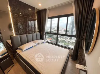 Modern bedroom with city view, featuring sleek design and large windows for natural light.