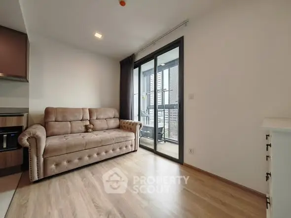 Modern living room with cozy sofa and balcony access in stylish apartment.