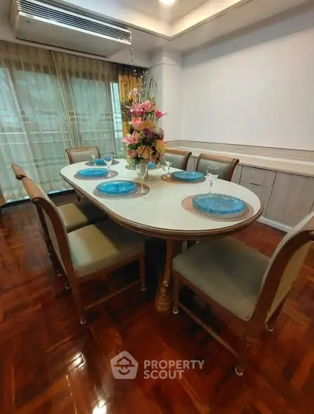 Elegant dining room with polished wooden floors and stylish table setting.