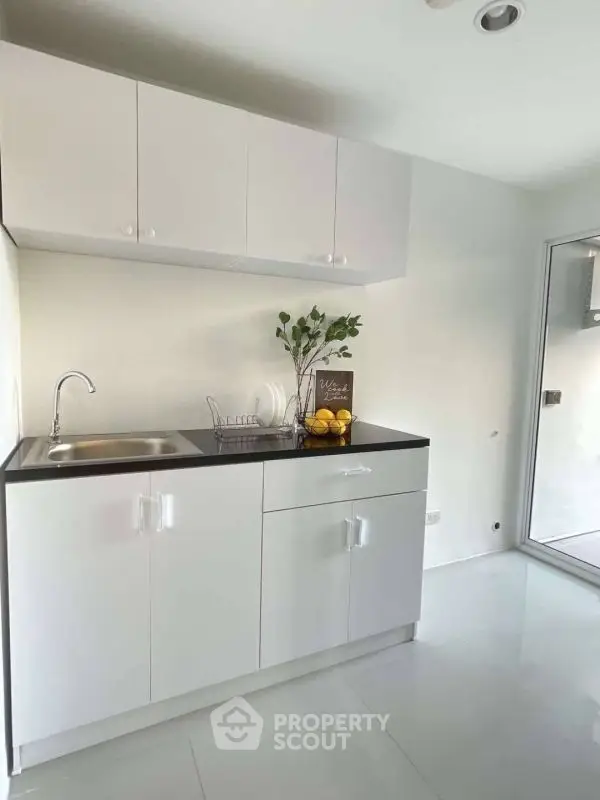 Modern minimalist kitchen with sleek white cabinets and natural light