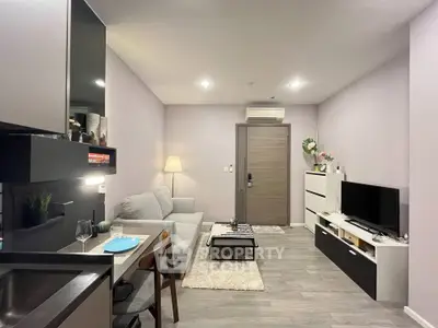 Modern living room with sleek furniture and open kitchen layout in stylish apartment.