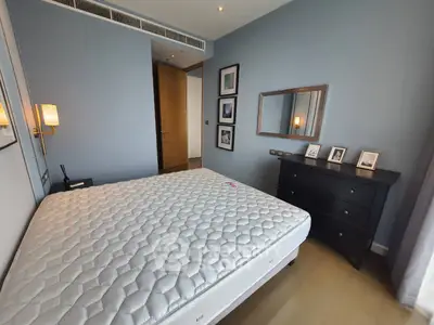Spacious bedroom with modern decor and ample natural light, featuring a comfortable mattress and stylish furniture.
