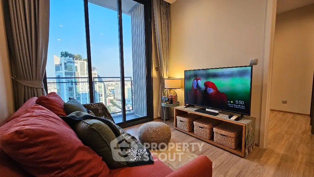 Modern living room with city view and balcony access, featuring cozy seating and stylish decor.