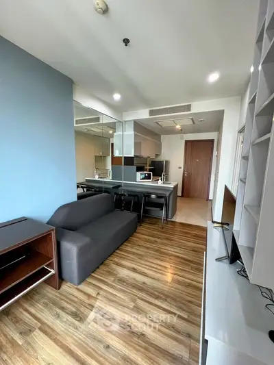 Modern living room with sleek furniture and open kitchen layout in a stylish apartment.