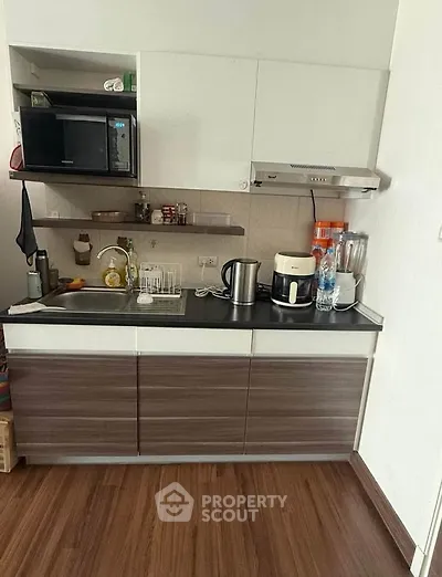 Compact modern kitchen with sleek cabinets and appliances, perfect for urban living.