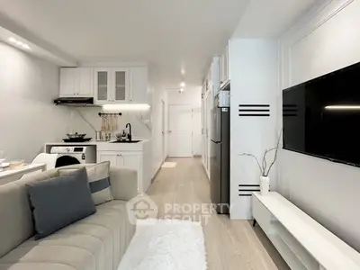 Modern living room with sleek kitchen and cozy sofa in open layout apartment.