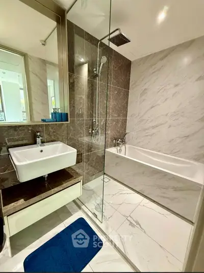 Luxurious modern bathroom with elegant marble tiles and sleek fixtures, featuring a spacious bathtub and stylish vanity.