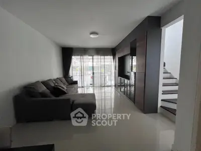 Spacious living room with modern sofa and large windows for natural light.