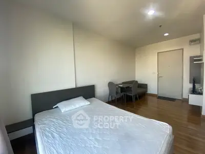 Spacious bedroom with modern furnishings and wooden flooring in a cozy apartment.