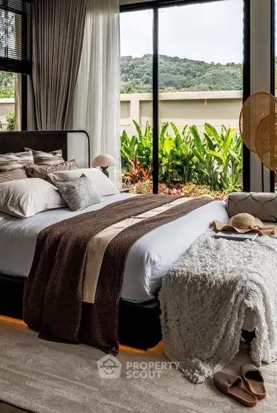 Luxurious bedroom with large windows offering stunning garden views, elegant decor, and cozy bedding.