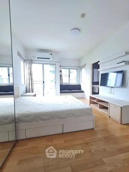 Bright modern bedroom with large windows and wooden flooring