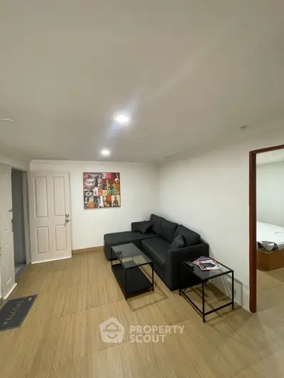 Cozy living room with modern black sofa and stylish decor in a contemporary apartment.