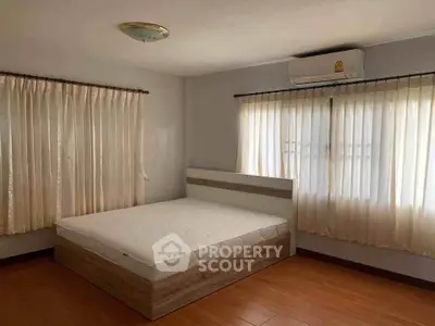 Spacious bedroom with natural light and modern furnishings